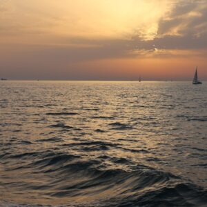 Sailboats drift peacefully on a serene sunset bay in Andalucía, Spain.
